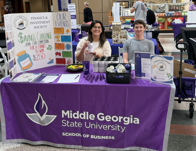 Two finance and investment society members at the recruiting table